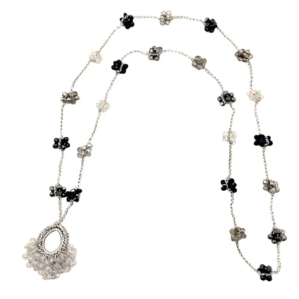 Collana Nebula: catena d’argento con charms floreali neri e chiari, pendente cristallo a goccia